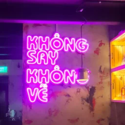 Neon signage featuring “Khong Say Khong Ve” text with vibrant glow effect