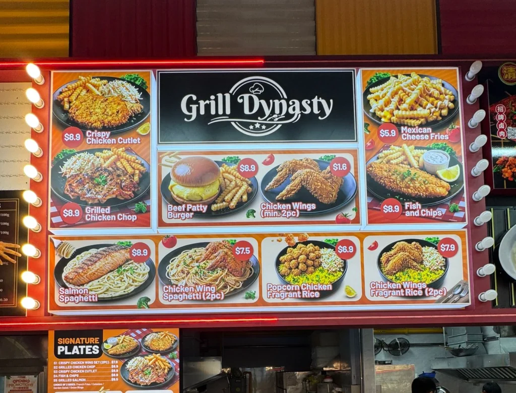 A brightly lit food stall menu lightbox panel for Grill Dynasty